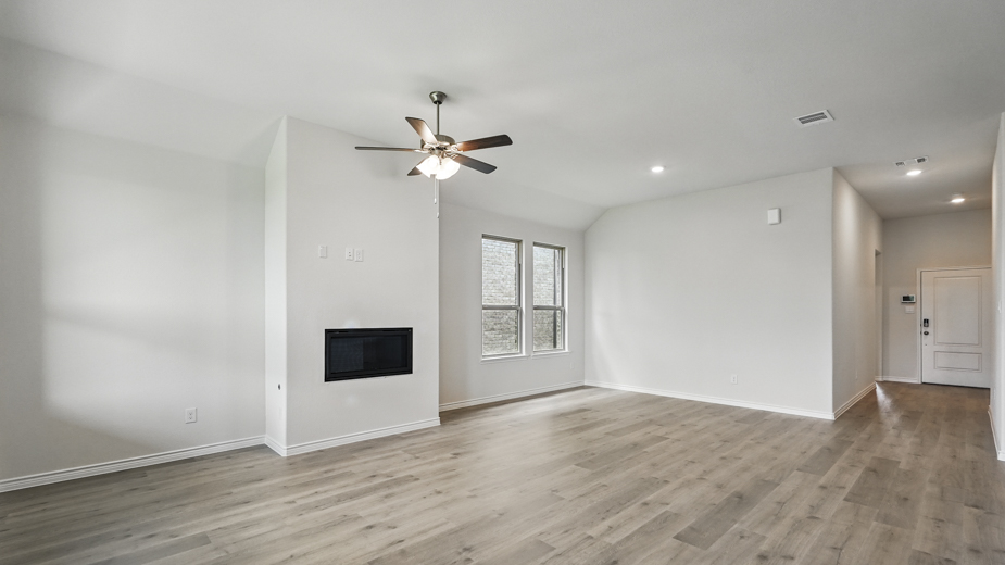 Living room with windows and kitchen with brown cabinets