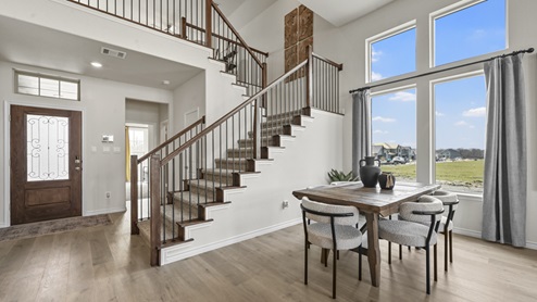 view of front door and stairs of large two story home