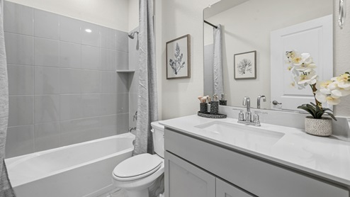 secondary bathroom with white countertop vanity and garden tub