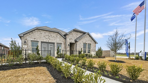 Madera sales model office with light brown brick and landscaping around sidewalk