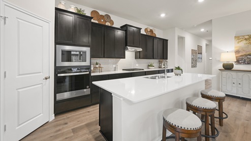 large kitchen with island with white countertops and brown cabinets