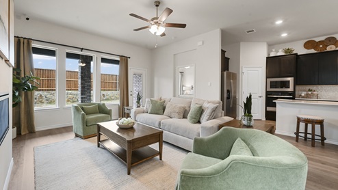 large living room with furniture and large windows with ceiling fan