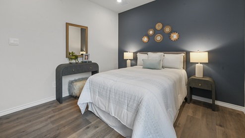 secondary bedroom with bed and accent wall