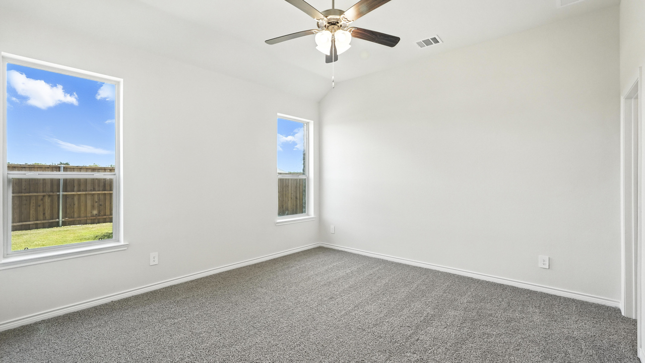 primary bedroom with hardwood floors with large windows
