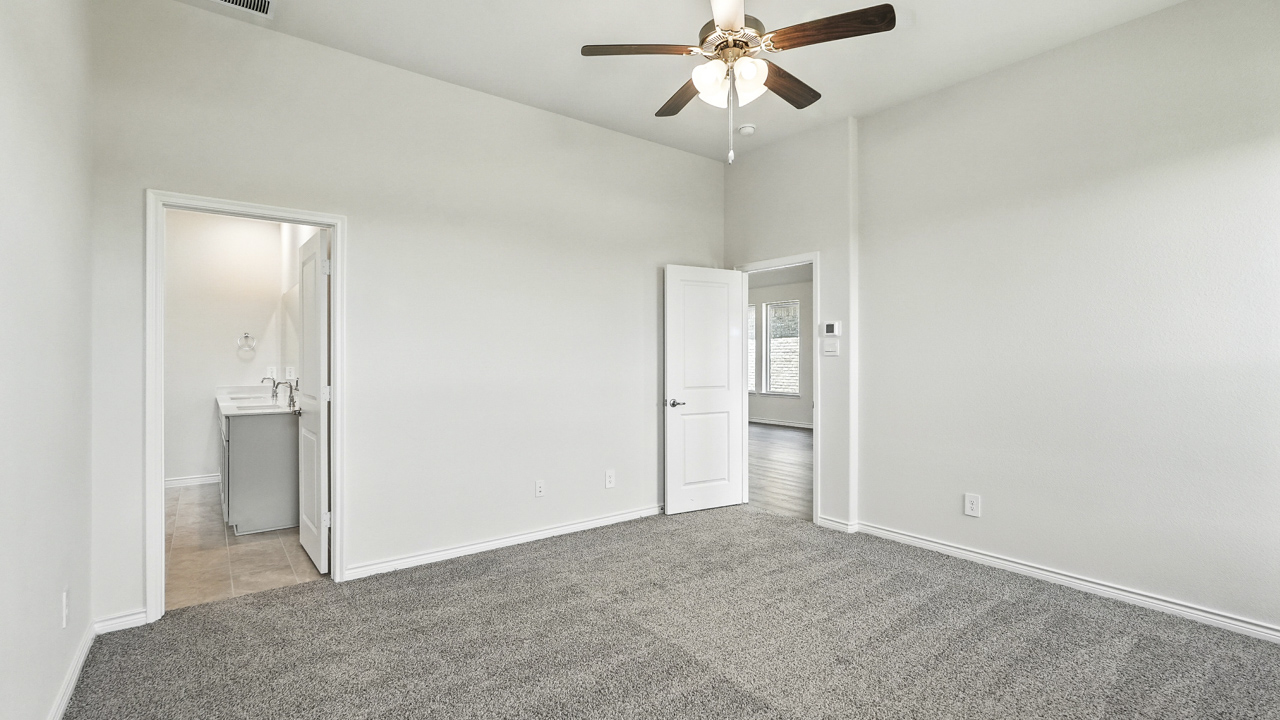 primary bedroom with hardwood floors with large windows
