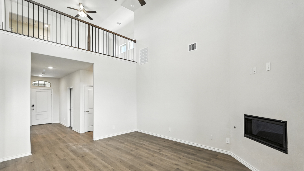 Open concept living area with hardwood floors and large windows providing natural light