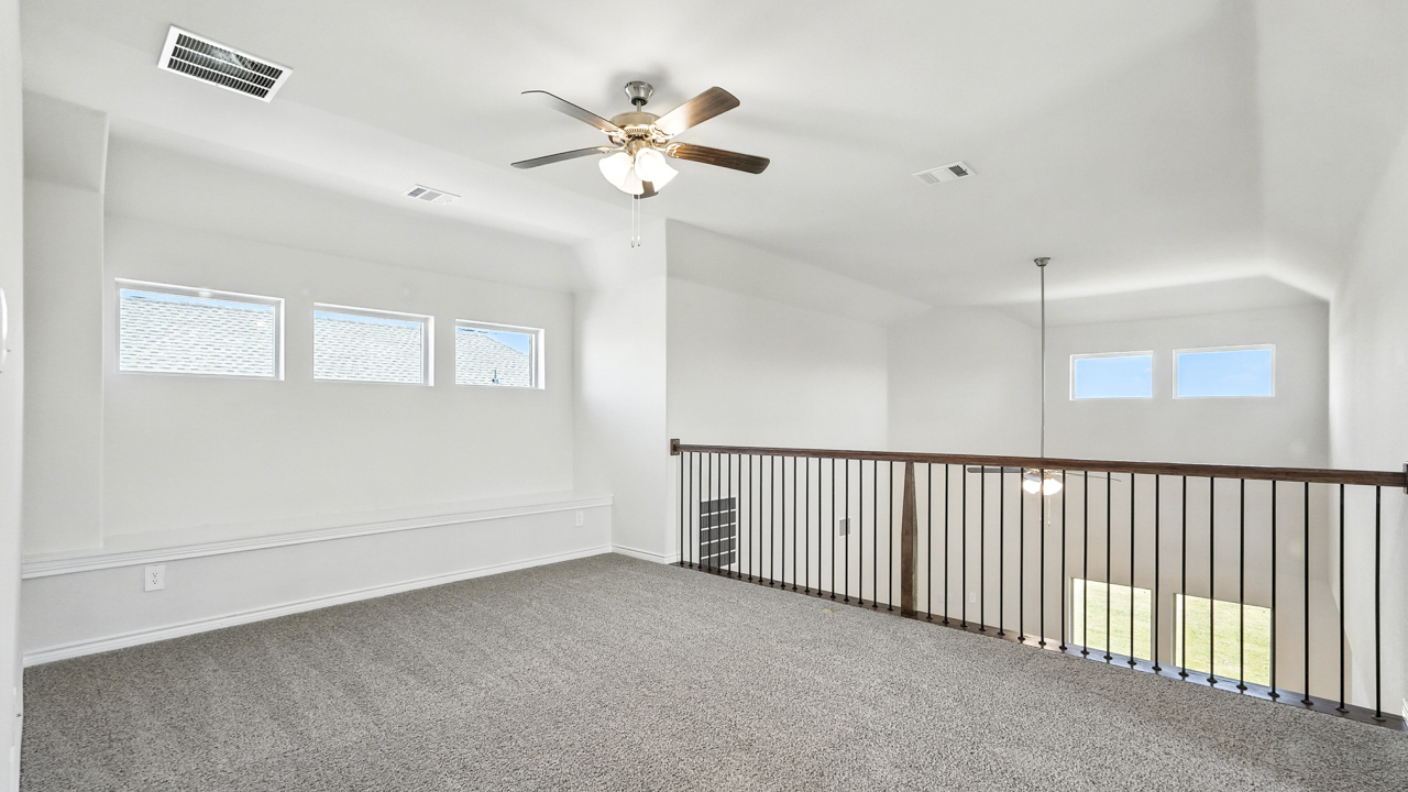 Upstairs movie room with railing overlooking the living area