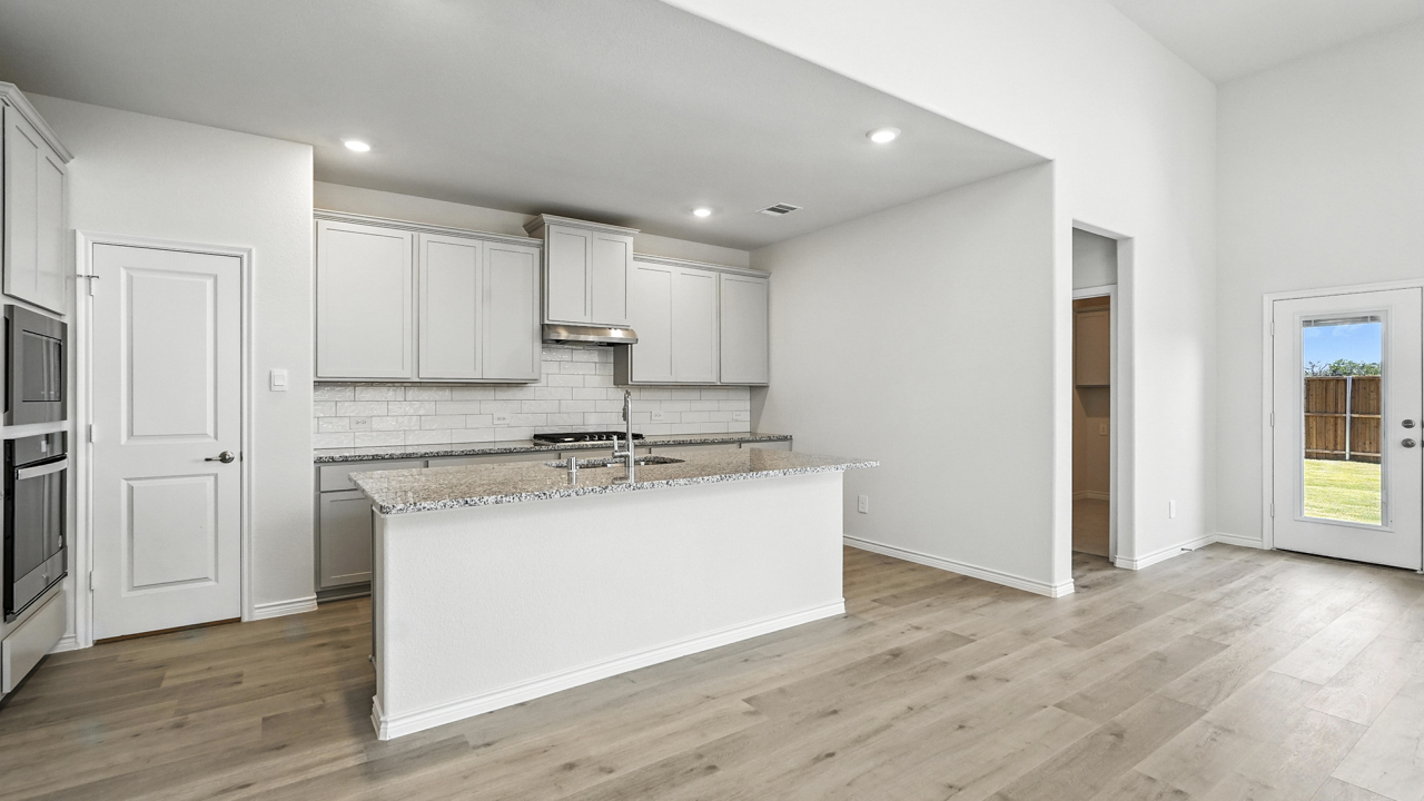 Kitchen island overlooking living room with windows
