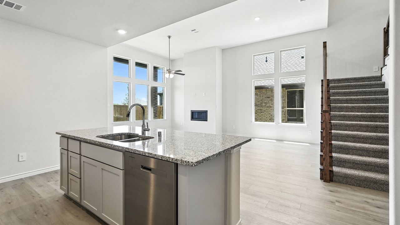 Kitchen island overlooking living room with windows