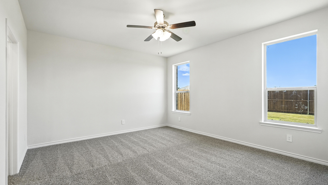 Primary bedroom with carpeted floors and window