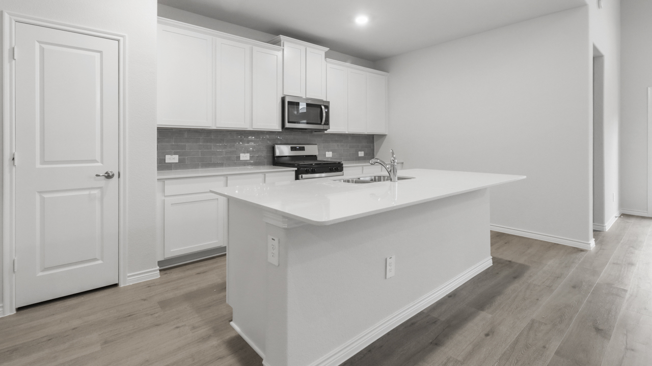 Large kitchen island with white counters and cabinets