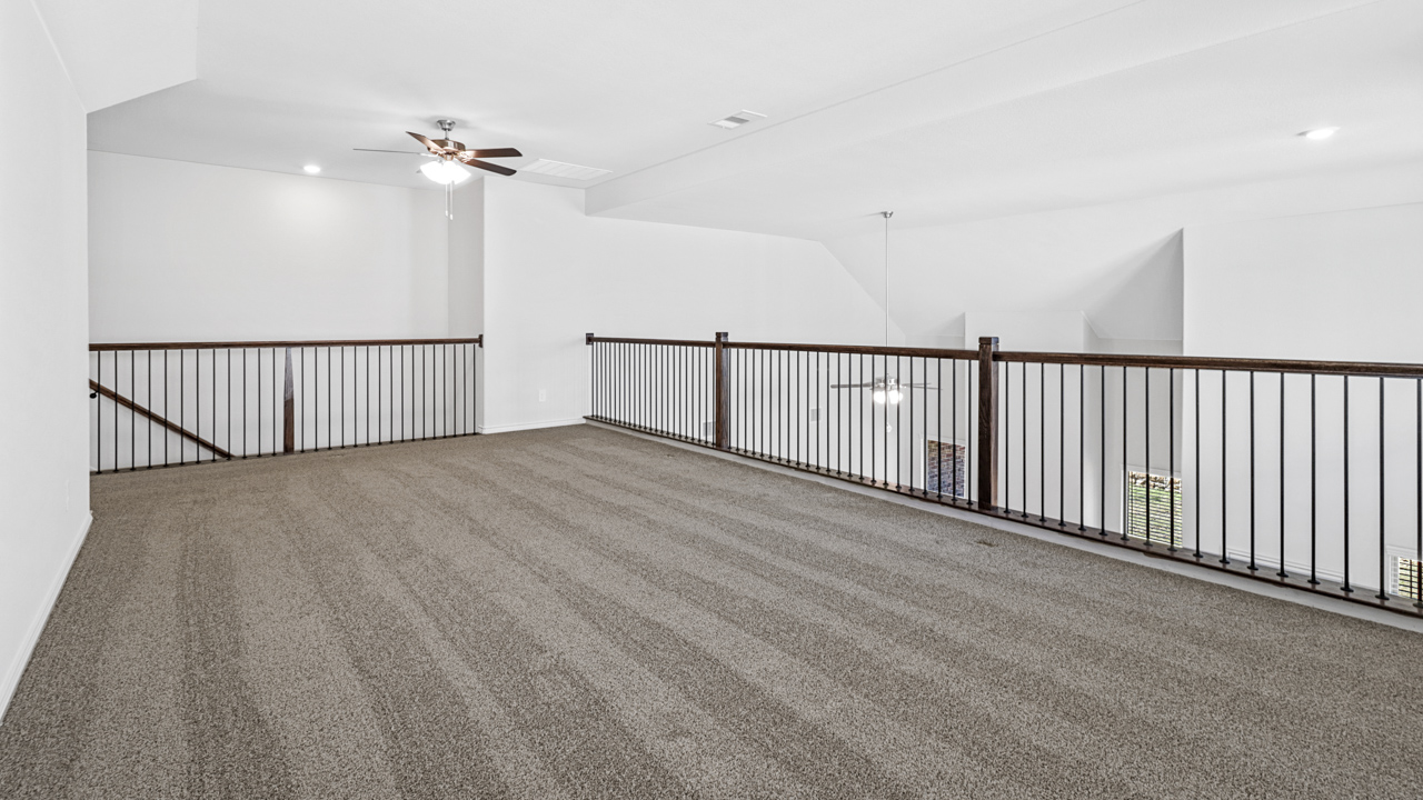 upstairs loft with carpet and windows