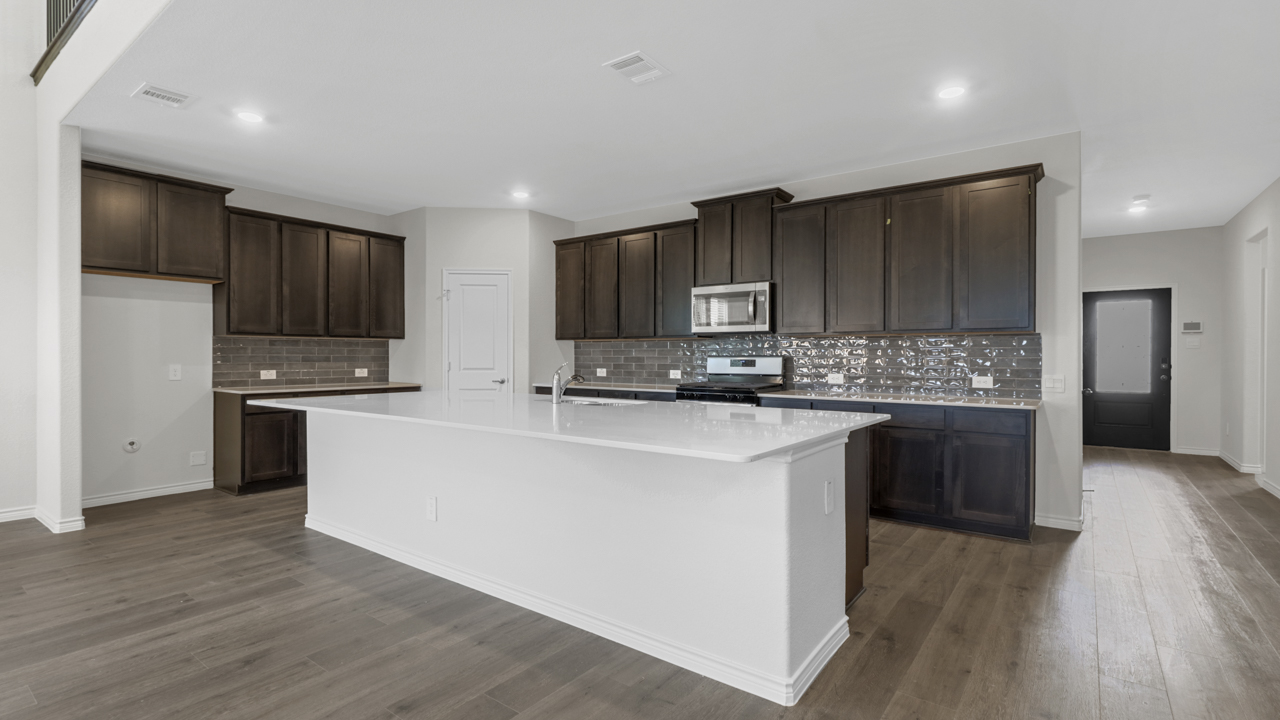 another view of a large kitchen with a large island in the middle