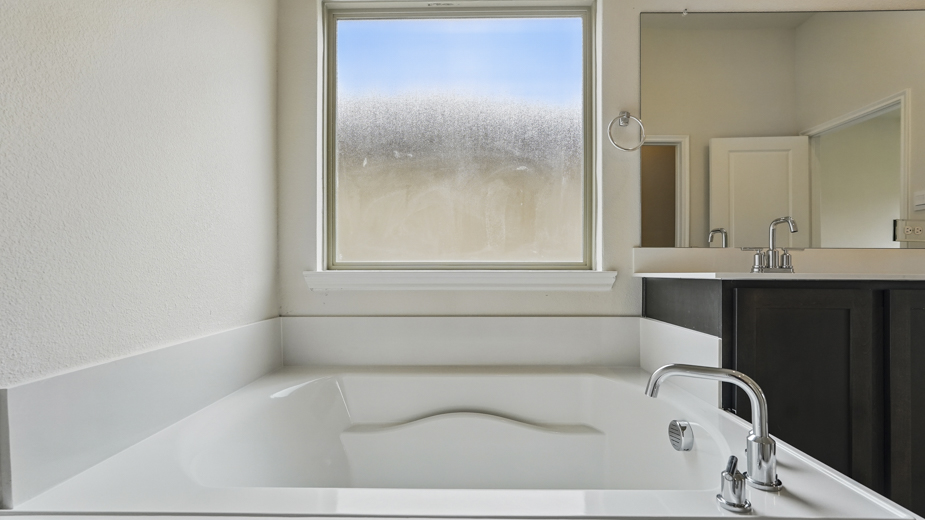 Primary bathroom witrh a decent sized bathtub.