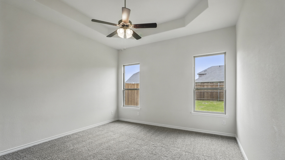 Primary bedroom with two windows for natural lighting.
