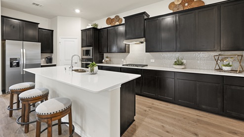 kitchen area with dark cabinets and light colored counters and island with hardwood floors