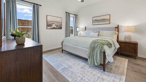 primary bedroom with hardwood floors with large windows