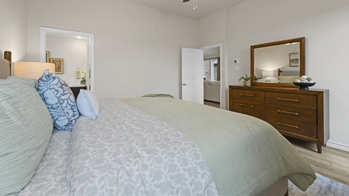 primary bedroom with hardwood floors with large windows