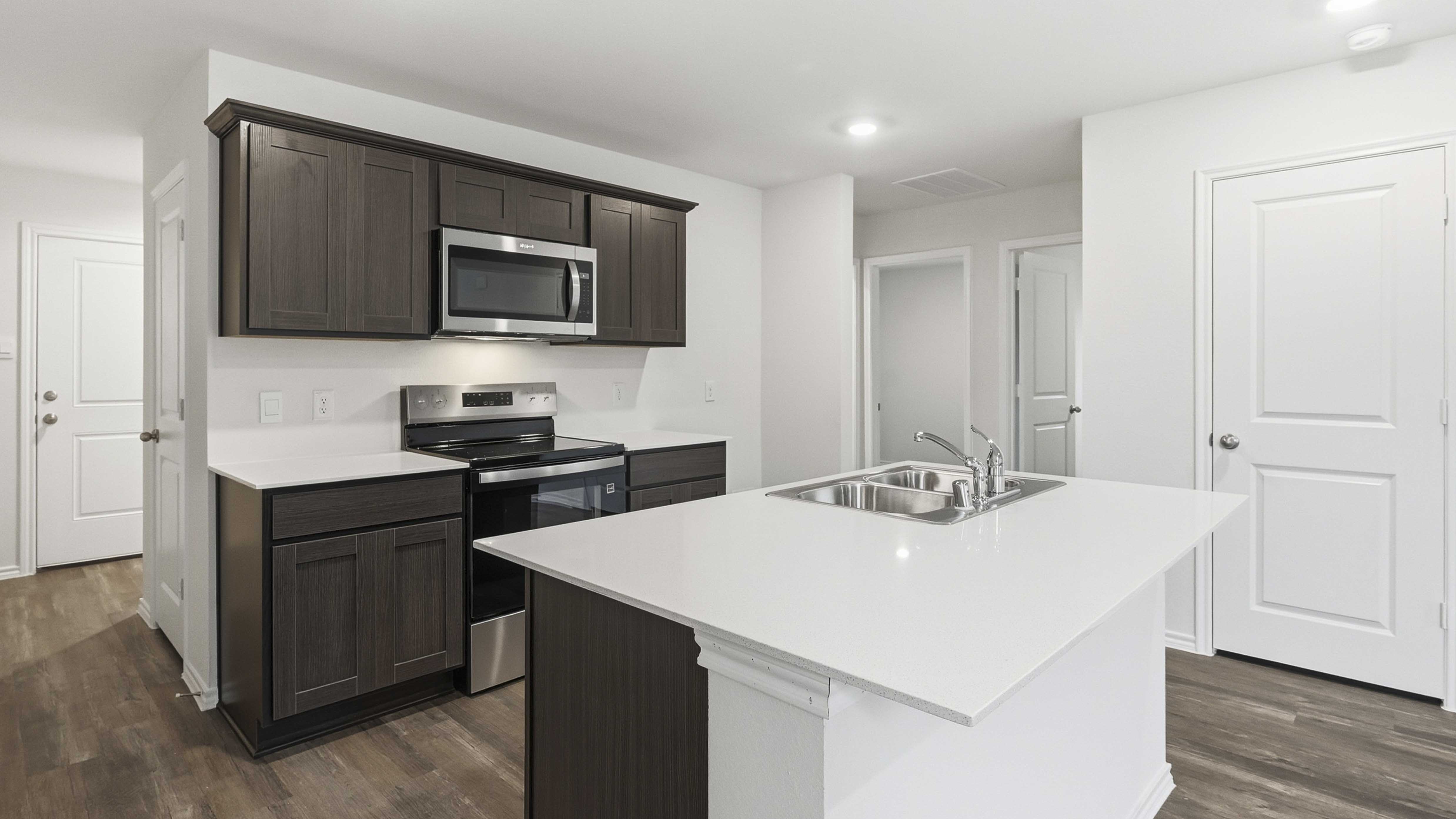 kitchen area with dark cabinets and white counters