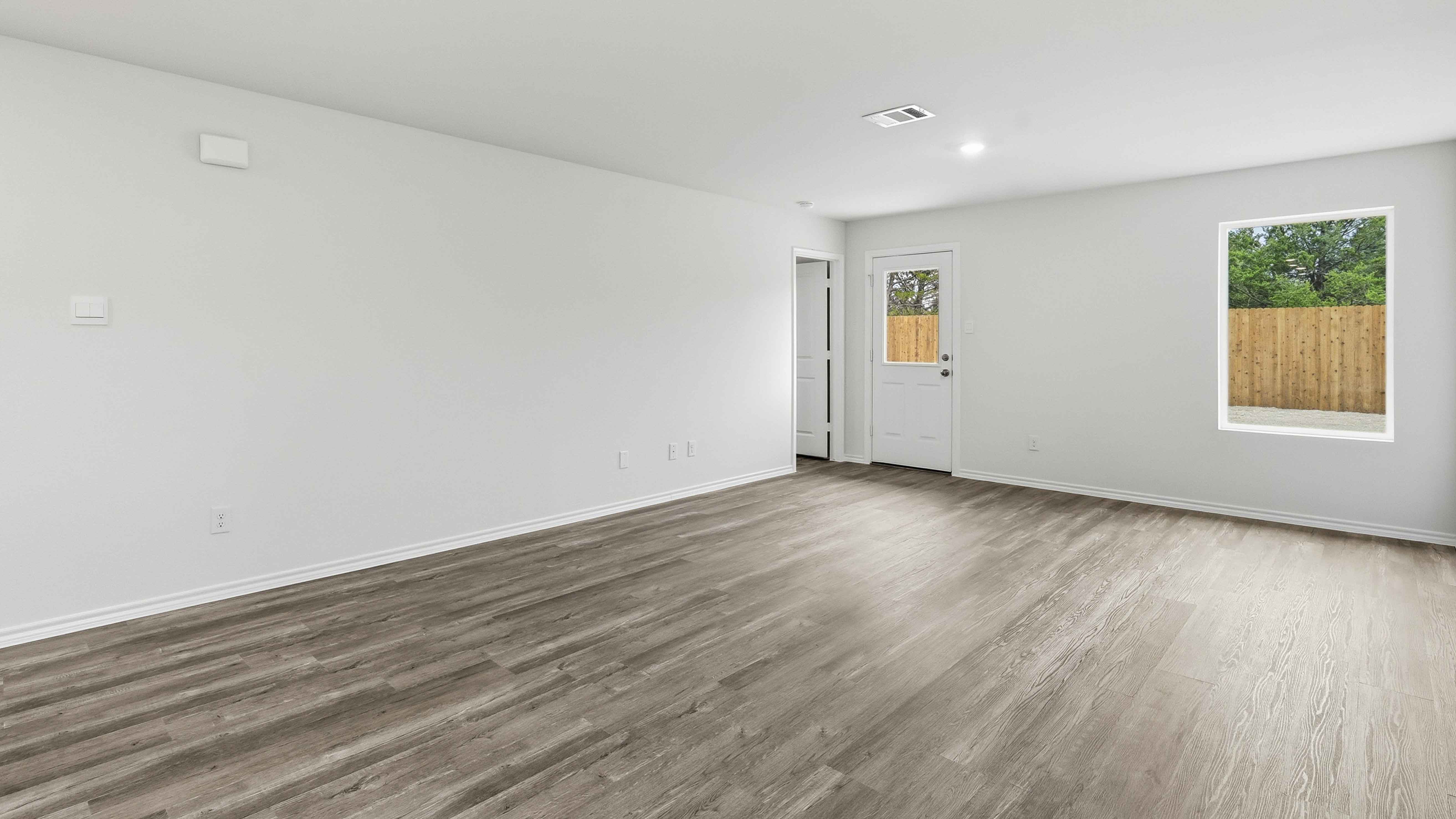 open concept living area with hardwood floors and large windows providing natural light