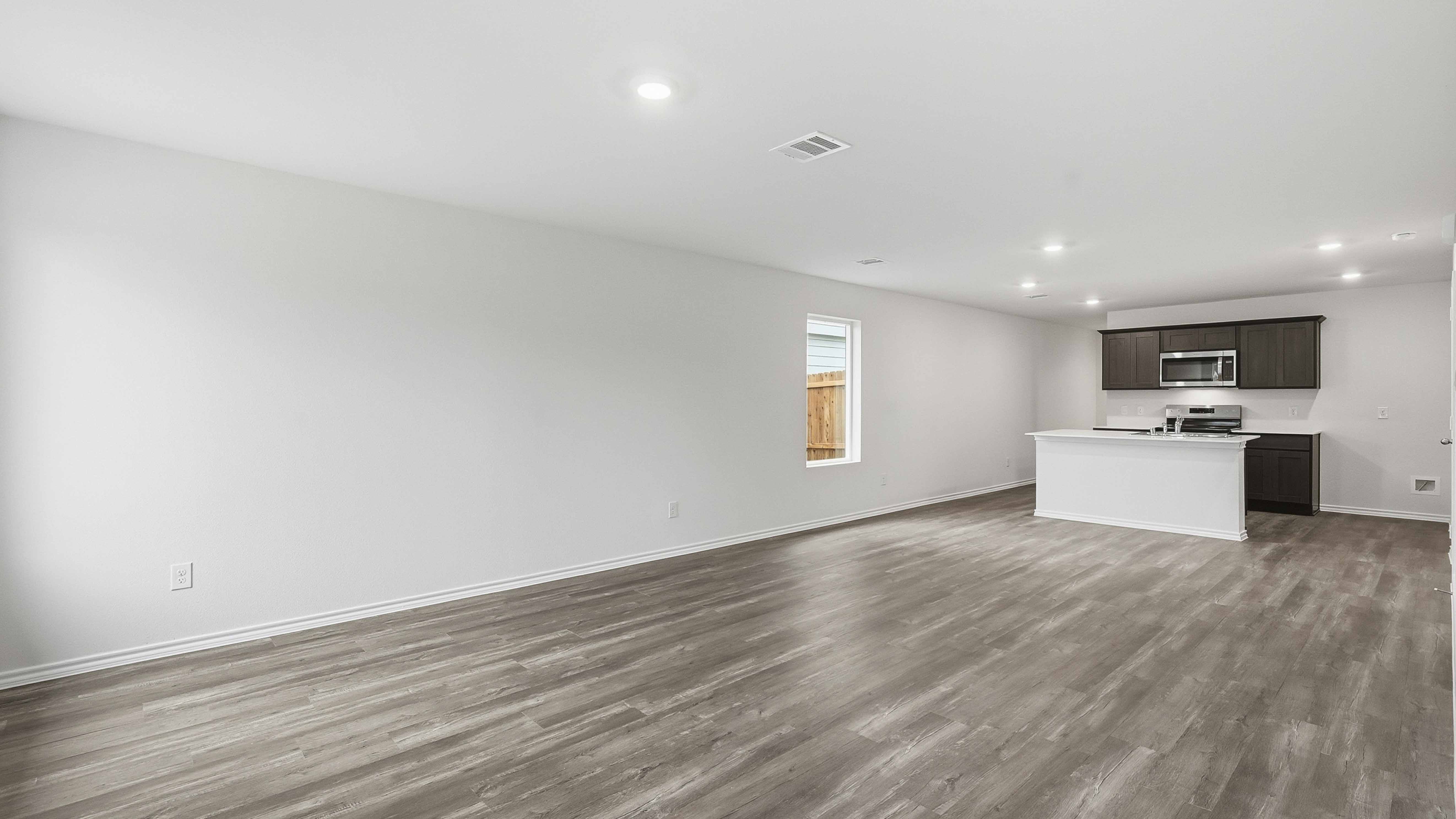 open concept living area with hardwood floors and large windows providing natural light