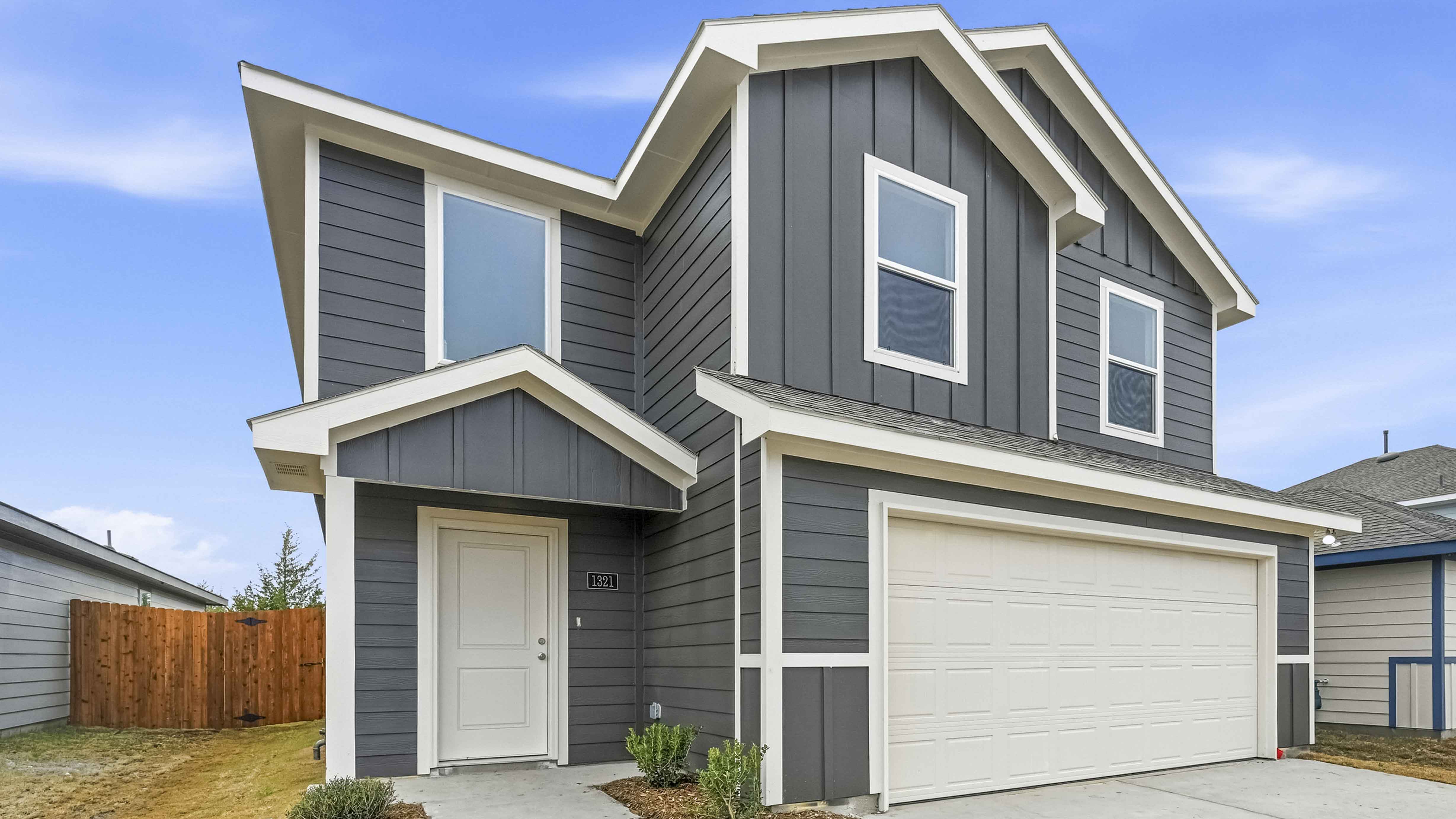 exterior of two story home with siding and large windows facing the front yard