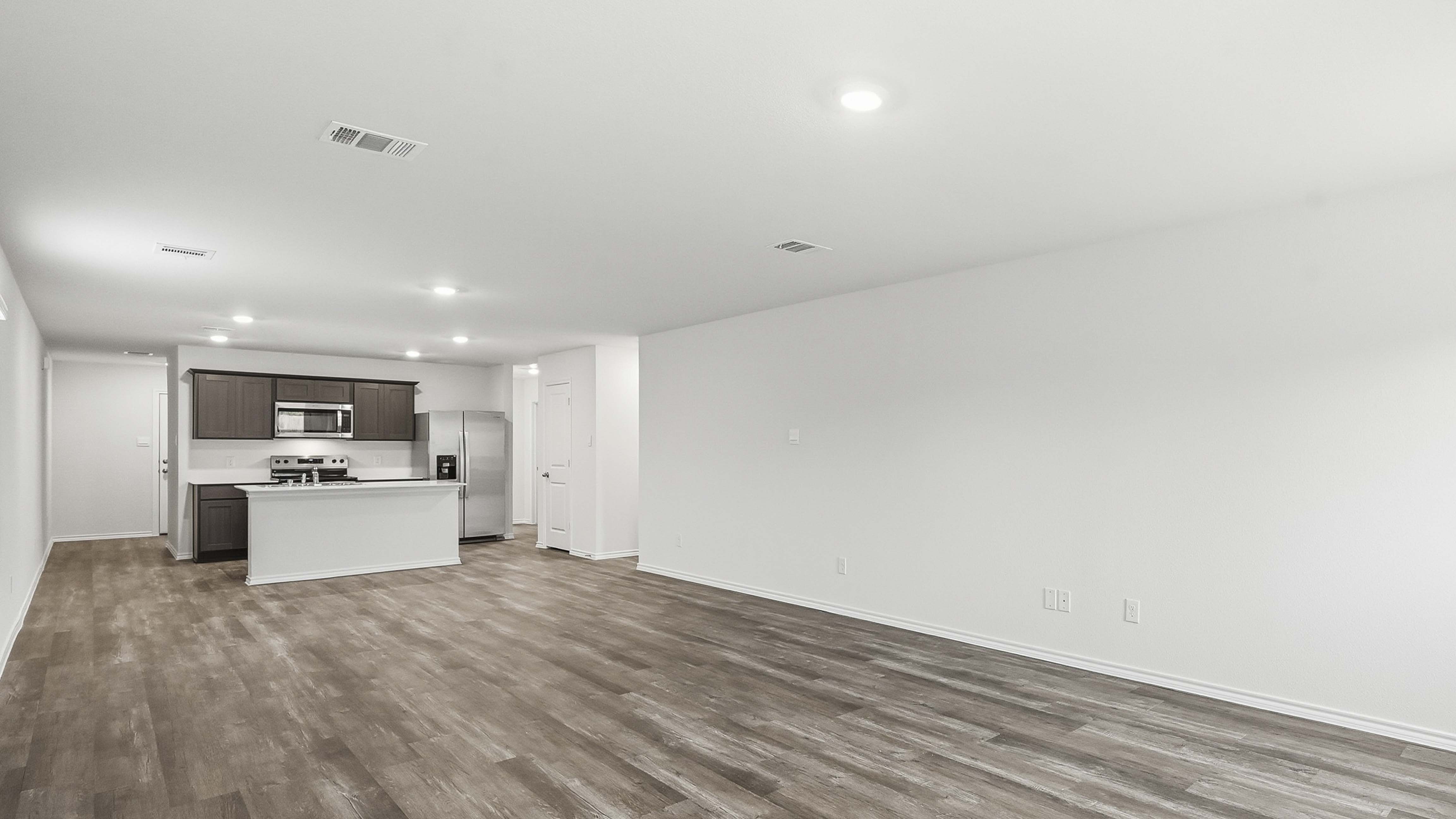 open concept living area with hardwood floors and large windows providing natural light