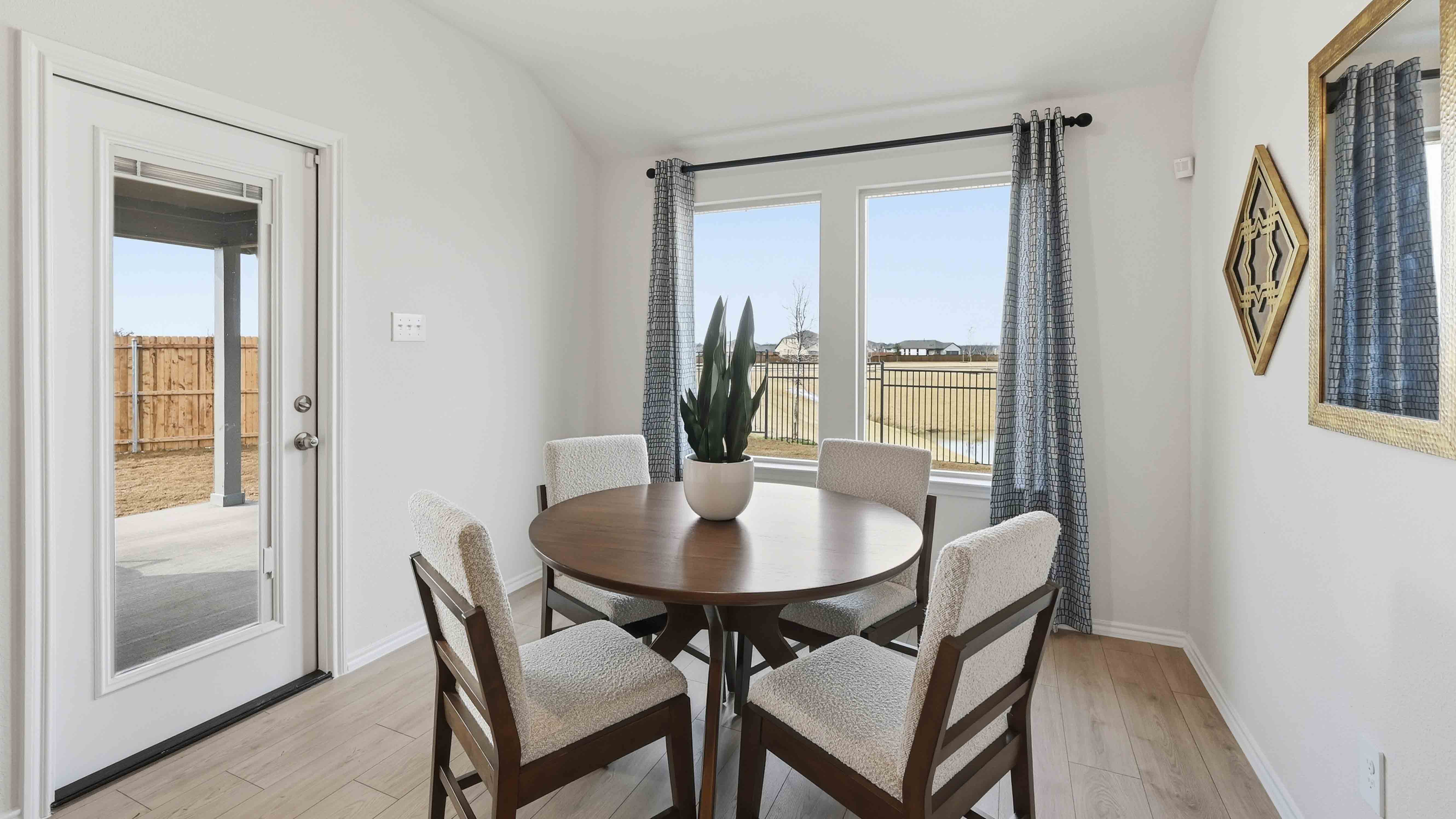 dining area with hardwood floors and large windows facing the backyard providing natural light