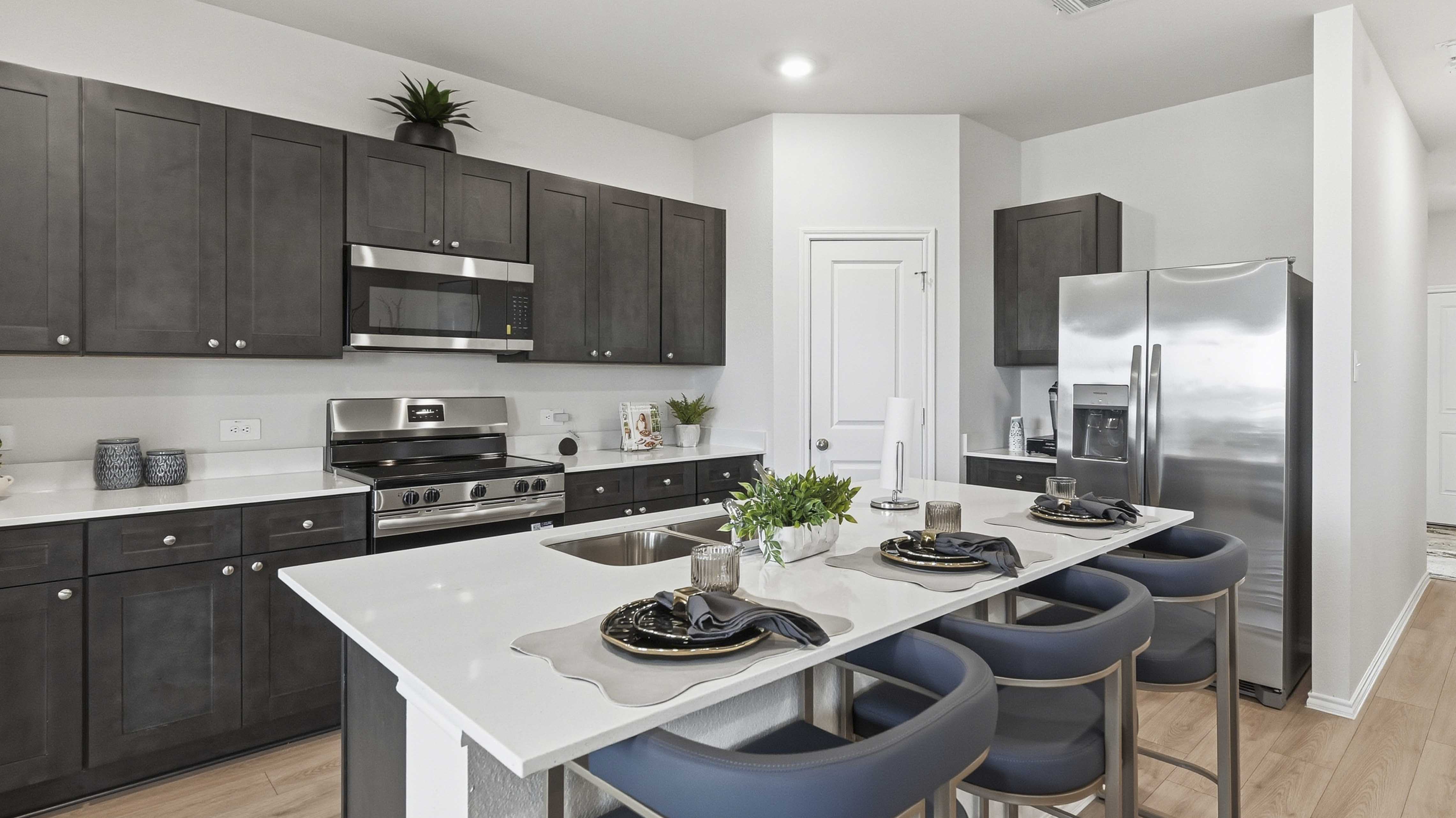 kitchen are with dark colored cabinets white countertops and kitchen island