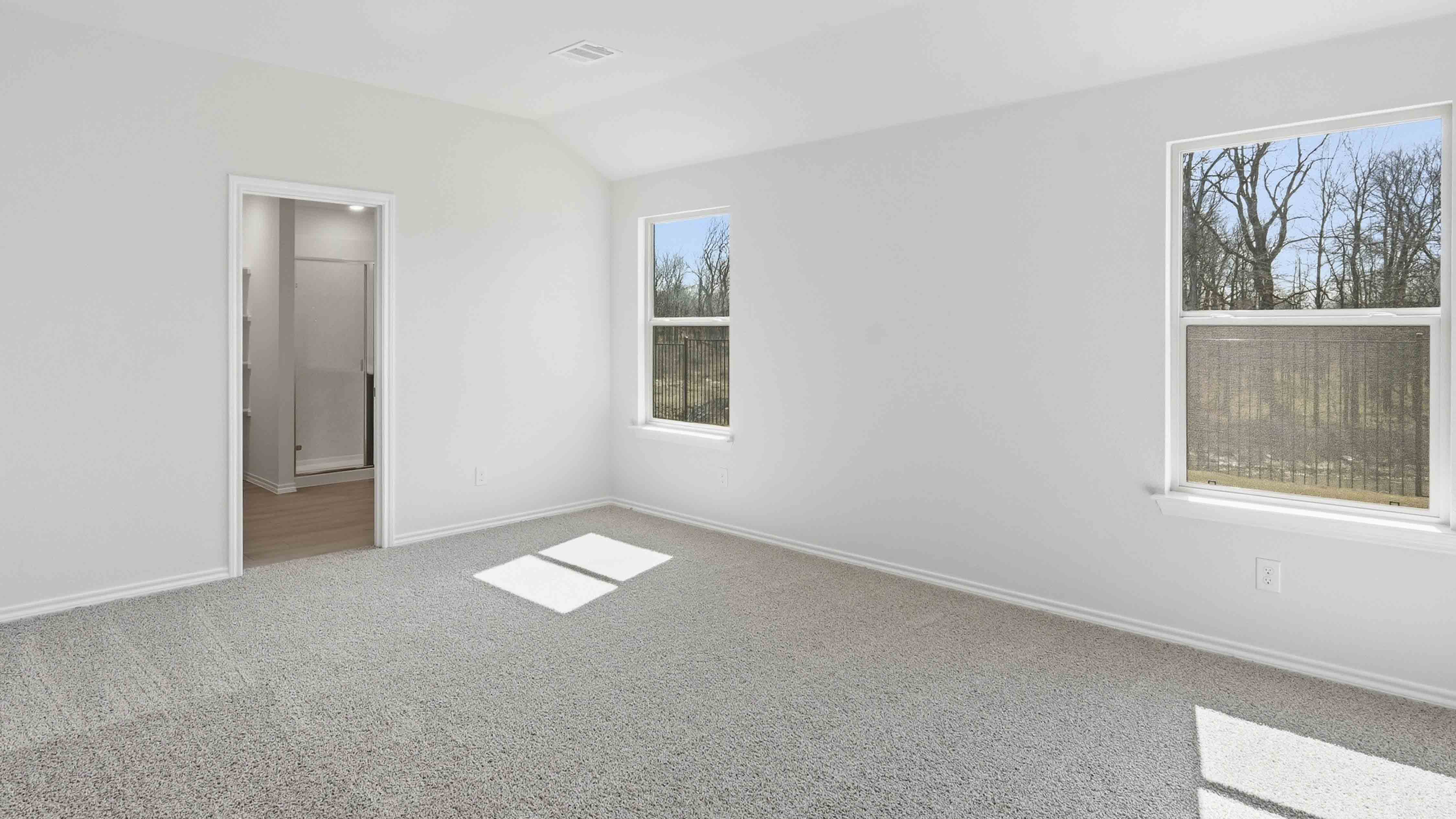 primary bedroom with large windows facing the backyard