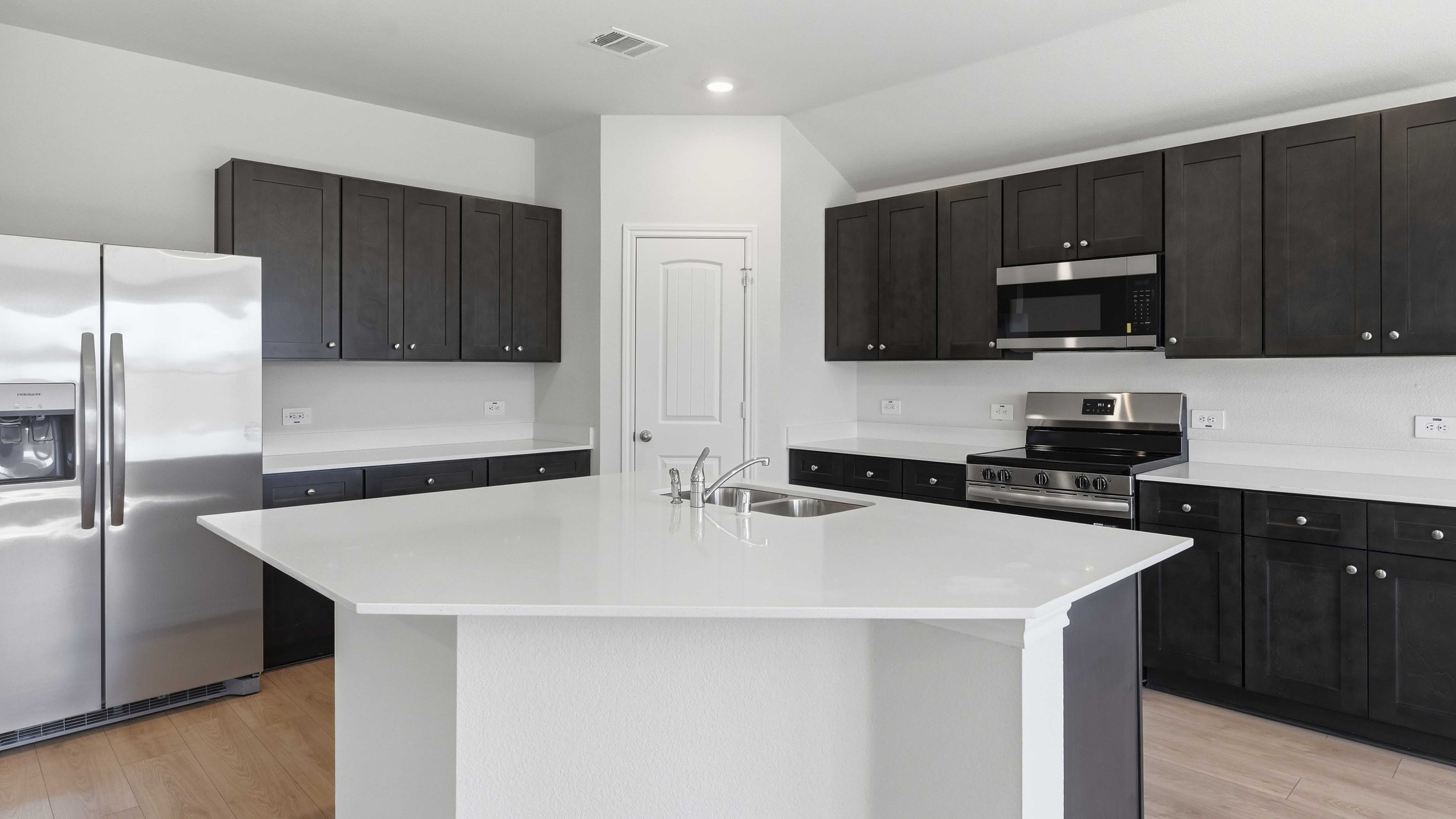 kitchen area with hardwood floors dark cabinets and white counters