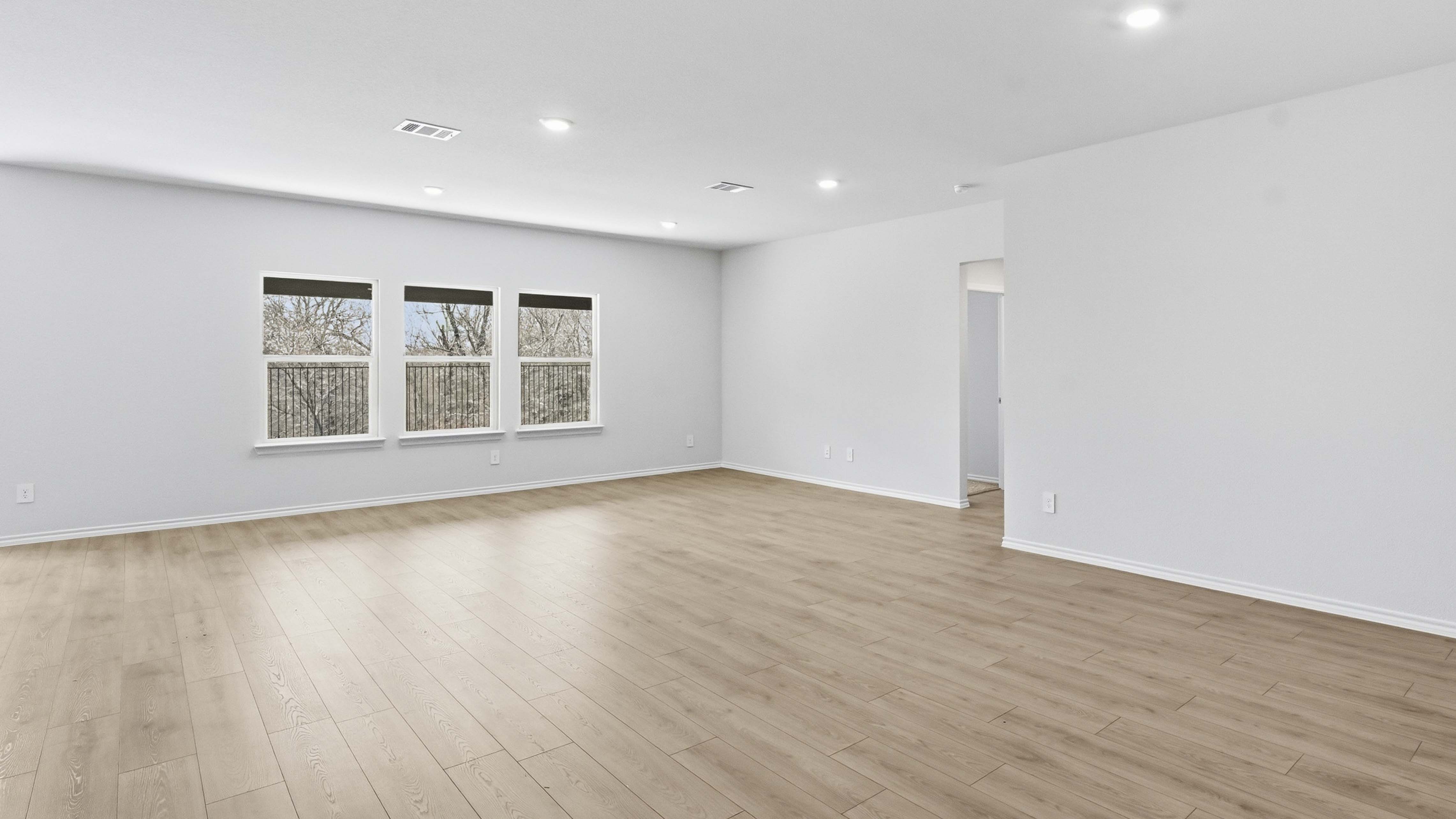 open concept living area with hardwood floors and large windows facing the backyard