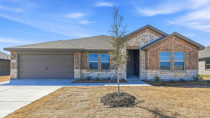 exterior of one story home with traditional brick and stone with large windows facing the front yard