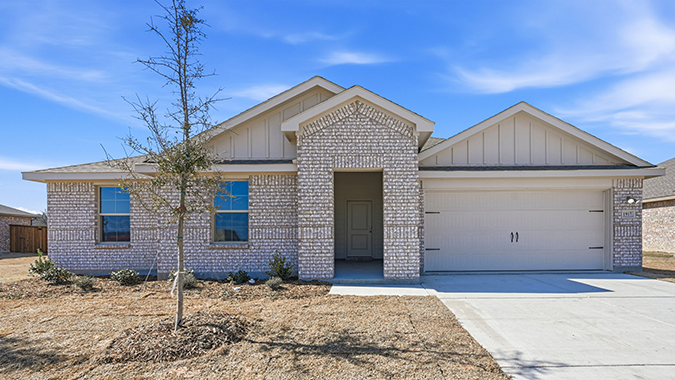 exterior of one story home with brick and large windows facing the front yard with middle front entry to the home