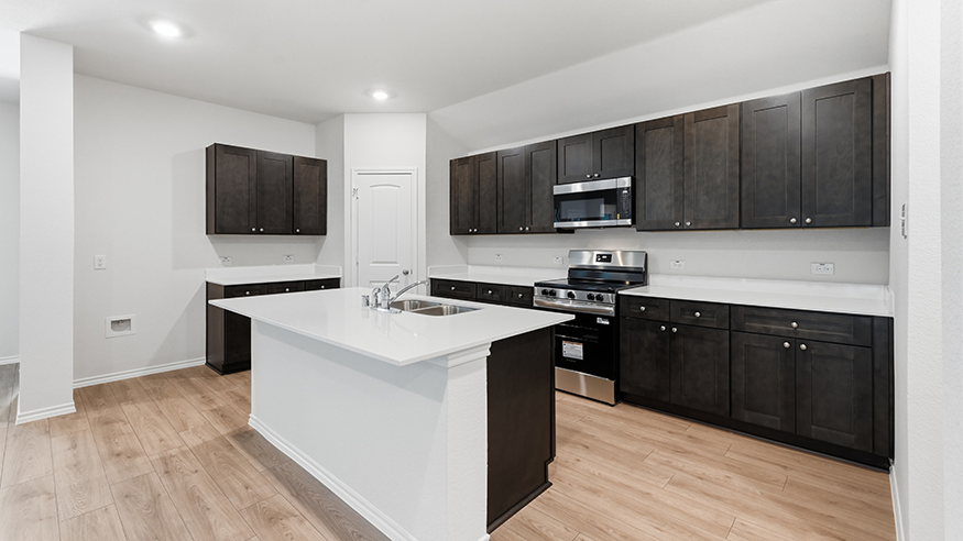 kitchen area with hardwood floors light colored counters and dark cabinets