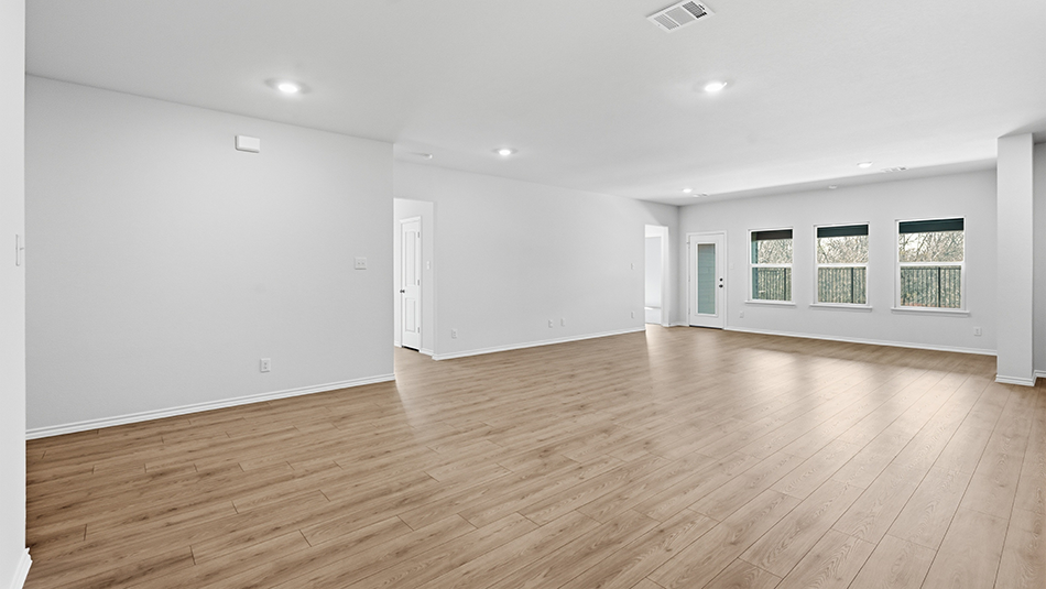 open concept living area with hardwood floors and large windows facing the backyard