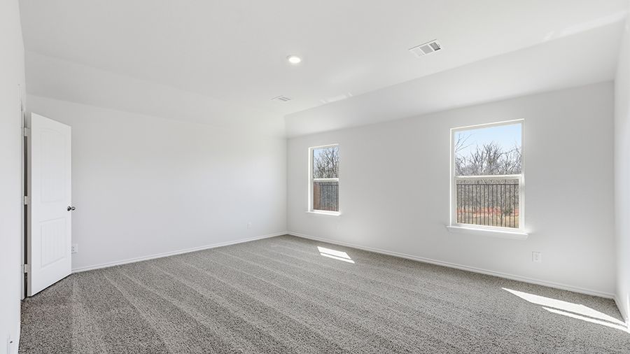 primary bedroom with large windows facing the backyard providing natural light