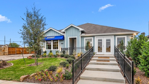 Single story model with blue siding and beautiful landscaping