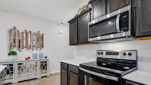 White counters with brown cabinets and stainless steel appliances