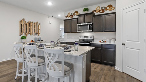 White counters with brown cabinets and stainless steel appliances