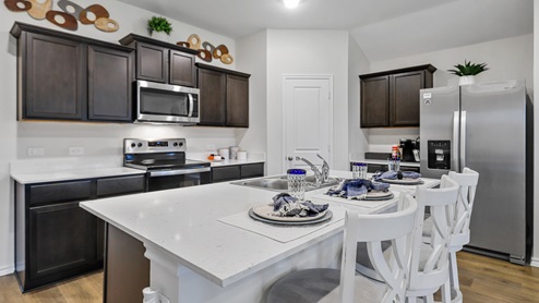 White counters with brown cabinets and stainless steel appliances