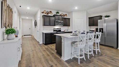 White counters with brown cabinets and stainless steel appliances