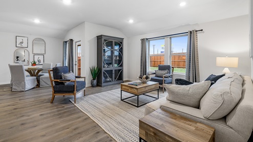 Living room with large window and furniture with view into breakfast nook