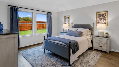 Primary bedroom with large window and furniture