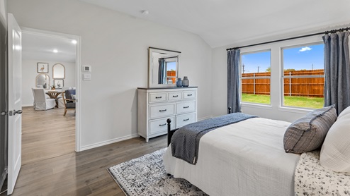 Primary bedroom with large window and furniture