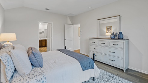 Primary bedroom with large window and furniture