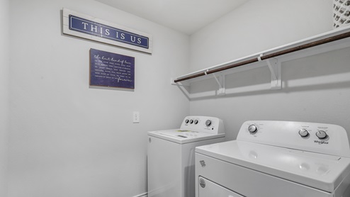 Utility room with washer and dryer and hanging rod