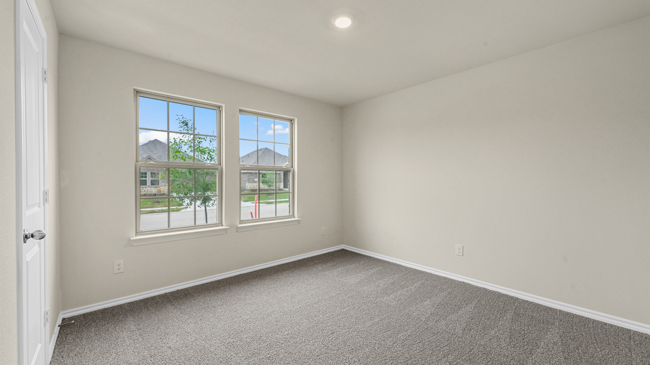 secondary bedroom with carpet and window