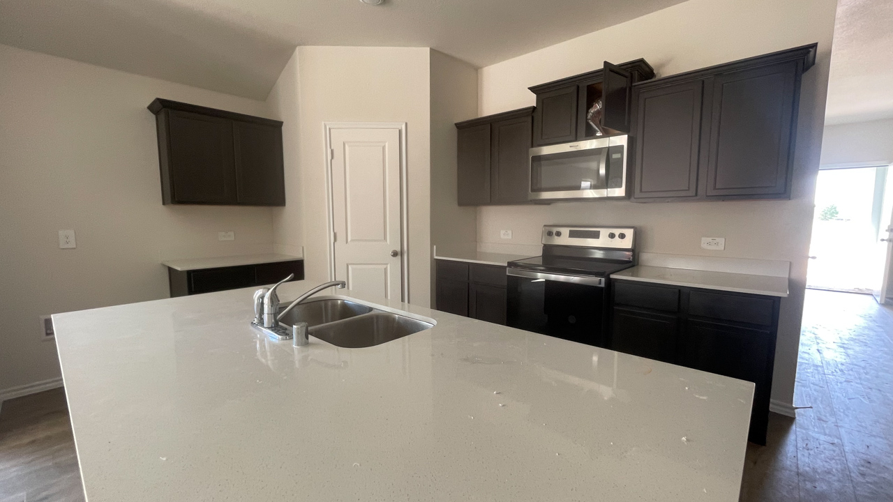 kitchen with light colored counters and dark cabinets