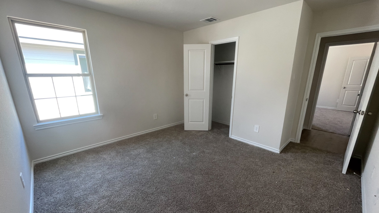 secondary bedroom with carpet and large window providing natural light